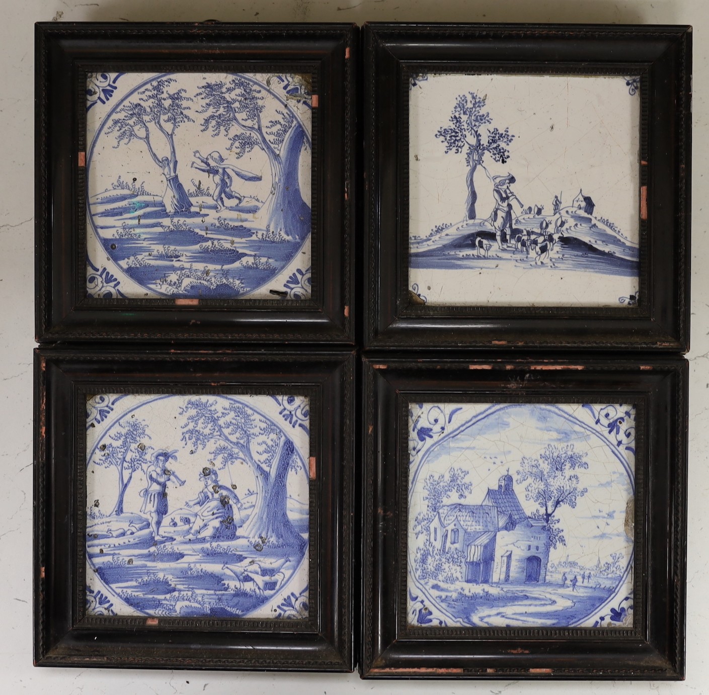 Four Delft blue and white landscape tiles, 18th century, each individually framed